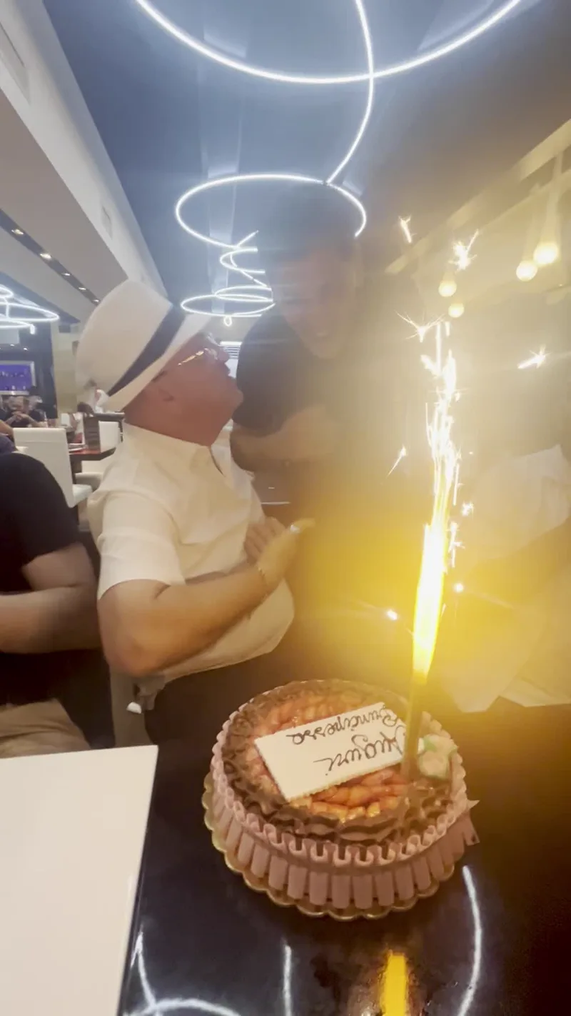 Il gruppo festeggia con una torta e una candela scintillante